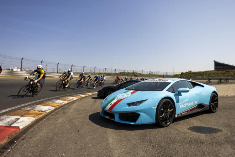 Deelnemers aan Cycling Zandvoort fietsen door een van de bochten op circuit zandvoort